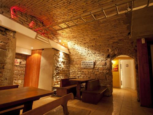 斯特拉斯堡勒格力隆酒店的餐厅设有木桌和砖墙