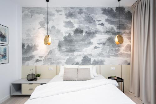 布加勒斯特FOUR Bedroom Apartment, Old Town Bucharest的卧室配有白色的床和壁画