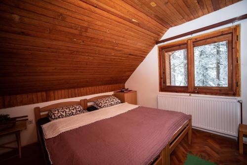 卡鲁德杰尔斯科巴尔Rustic Home Tara的木制客房内的一间卧室,配有一张床