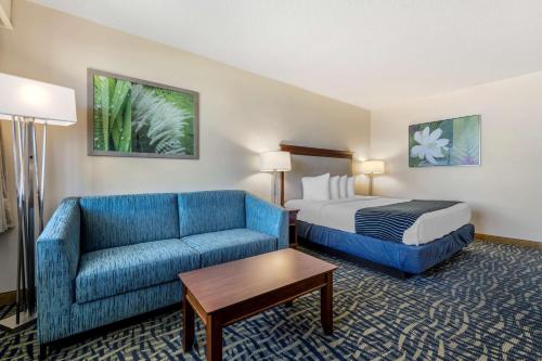 可可比奇可​​可海滩贝斯特韦斯特套房酒店的酒店客房,配有床和蓝色的沙发