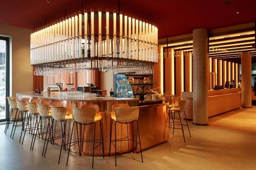 美因河畔法兰克福Scandic Frankfurt Hafenpark的餐厅设有酒吧,在房间内摆放着凳子