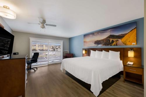圣西米恩Pacific Coast Roadhouse Hotel的酒店客房设有一张白色大床和一个窗户。