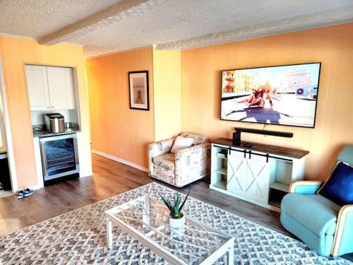 大洋城Spacious 2 Bedroom and 2 Baths的客厅配有沙发和墙上的电视