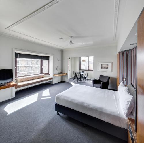 悉尼悉尼丽景阁酒店的一间卧室配有一张大床和一张书桌
