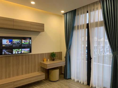 富国Liên’s Mini Hotel的客房设有电视和带窗帘的窗户。