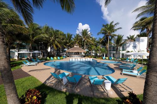 莫雷洛斯港Margaritaville Island Reserve Riviera Cancún - An All-Inclusive Experience for All的一个带蓝色椅子的游泳池,棕榈树