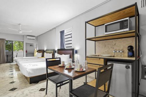 梅里达Suites Reforma by HomiRent的酒店客房配有床、桌子和微波炉