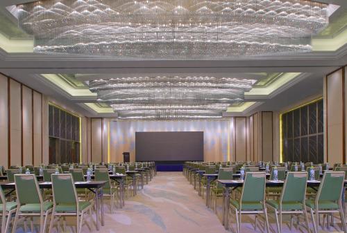 青岛青岛威斯汀酒店（Ins红人首选）的一间会议室,配有桌椅和屏幕
