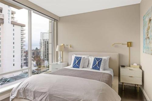 维多利亚Luxury downtown 2 bedroom suite with AC and Pool的一间卧室设有一张床和一个大窗户