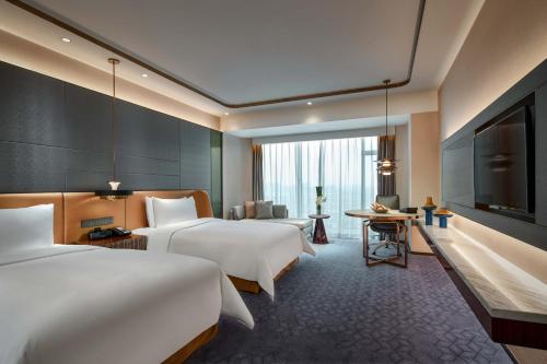 上海上海虹桥绿地铂瑞酒店的酒店客房设有两张床和一台平面电视。