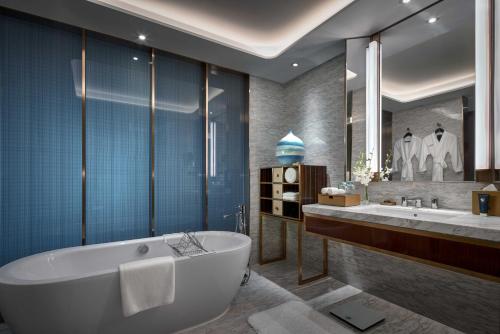 上海上海虹桥绿地铂瑞酒店的一间带浴缸和大镜子的浴室