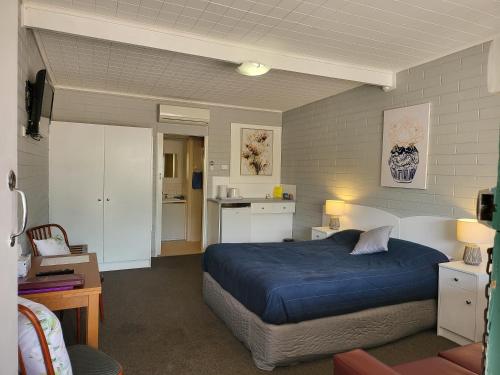 PeterboroughPeterborough Motel的一间带蓝色床的卧室和一间厨房