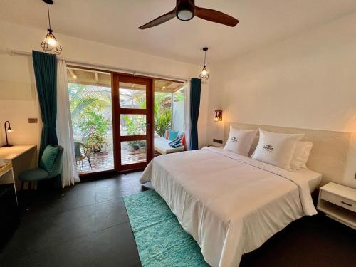 迪古拉Seaside Dhigurah的一间卧室配有一张带吊扇的床