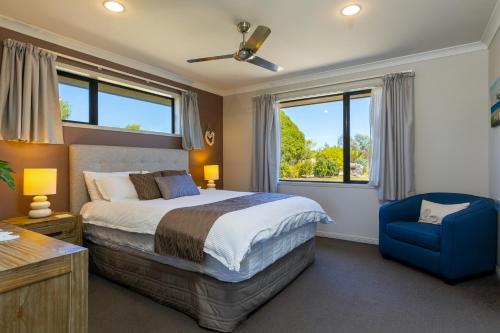 布伦海姆Ocean View Beachfront Apartment的一间卧室配有一张床和一张蓝色椅子
