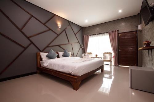 帕夭โรงแรมบ้านมะกรูด Baan Ma Grood Hotel的一间卧室配有一张大床和木制床头板
