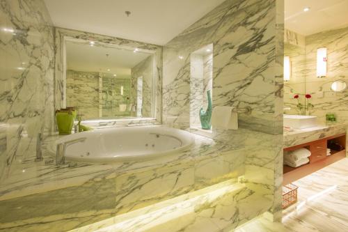北京北京艾维克酒店的一间带浴缸和大镜子的浴室