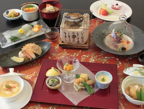 函馆花菱酒店的餐桌上放有盘子和碗的食物