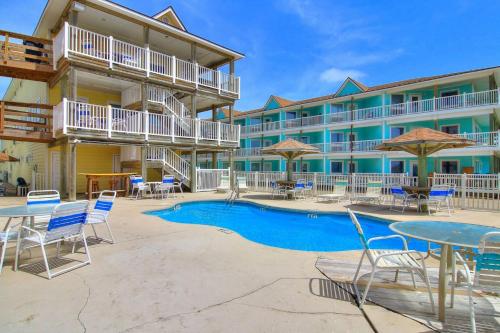 阿兰瑟斯港BeachGate CondoSuites and Oceanfront Resort的一个带游泳池和桌椅的度假酒店