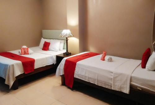 宿务RedDoorz Plus New Era Budget Hotel Mabolo former RedDoorz near Landers Superstore Cebu City的酒店客房,配有两张带红色包裹的床