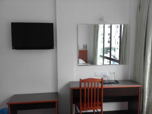 米里101酒店的客房设有带镜子和椅子的书桌