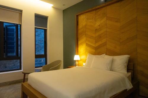 Liên Trì (4)Khách sạn gần biển Karina Phú Yên的卧室配有白色的床和木制床头板