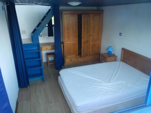 屈斯里Maison flottante sur la seille的一间卧室设有一张床和一个蓝色的楼梯