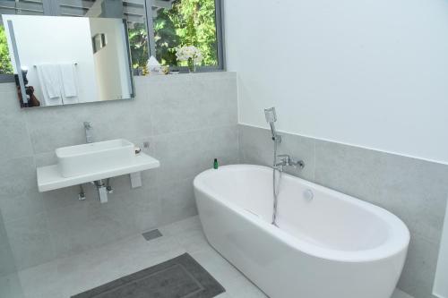 本托塔Eldezo Relax Paradise (Pvt) Ltd的浴室配有白色浴缸和水槽