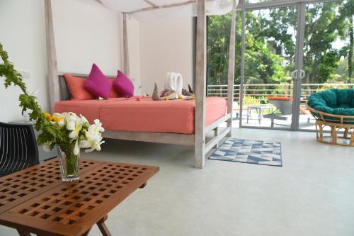 本托塔Eldezo Relax Paradise (Pvt) Ltd的一间卧室配有一张床和一张花瓶桌子