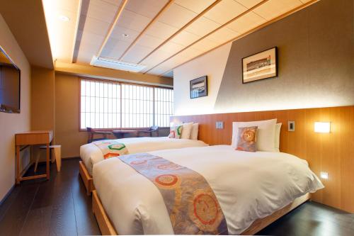 京都Gion Misen的酒店客房设有两张床和电视。