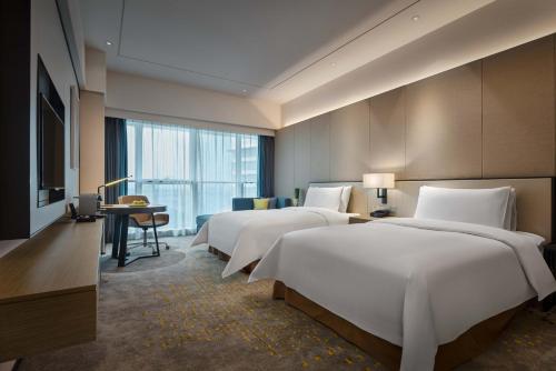 上海上海虹桥绿地铂骊酒店的酒店客房内的一排床位