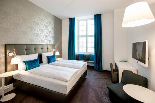 马格德堡马格德堡一号汽车旅馆的配有一张床和一把椅子的酒店客房