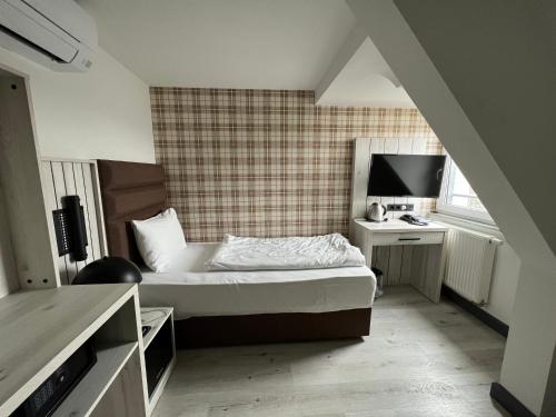 科隆Hotel Innception的一间卧室配有一张床和一张书桌及电视