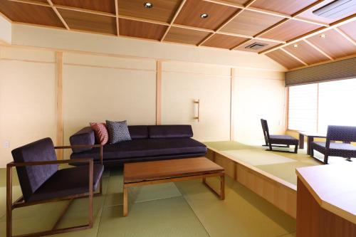 松本玉之汤酒店的客厅配有沙发和两把椅子