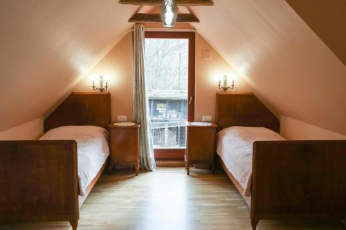 萨格勒布Country house with a pool in Medvednica Nature Park的阁楼卧室设有两张床和窗户。