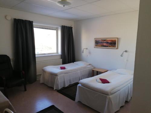 本茨福什Hotell Hemgården的酒店客房设有两张床和窗户。
