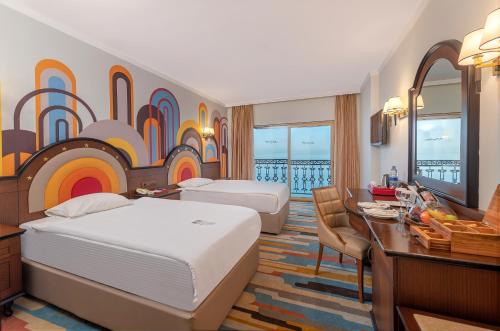 安塔利亚Megasaray Westbeach Antalya的酒店客房配有两张床和一张书桌
