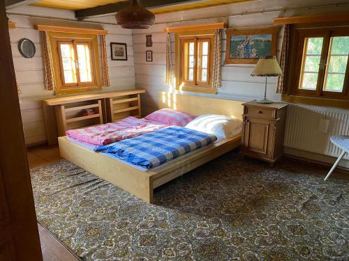代斯纳Roubenka u potoka Jizerské hory的卧室配有一张床、一张书桌和窗户。
