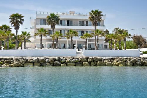 斯达林西达里比奇酒店的水边种有棕榈树的白色建筑