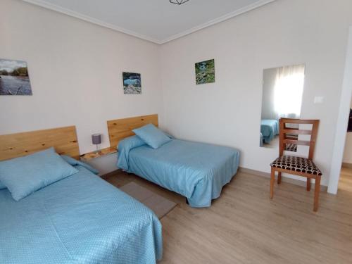 苏安塞斯La Casa del Limonero的一间卧室配有两张床和椅子