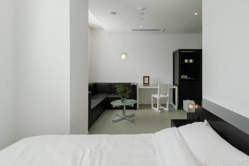 首尔Mangrove Dongdaemun的白色卧室配有床和沙发
