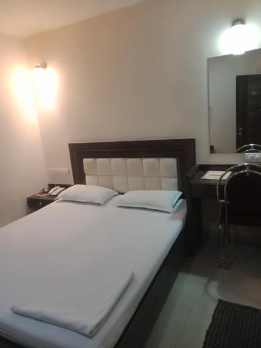 孟买VALA JANU HOTELS PVT LTD的一间卧室配有床、水槽和镜子