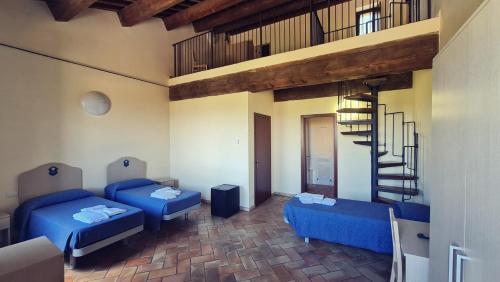 卡梅里诺Borgo de' Varano by Hotel I Duchi的客厅设有蓝色的沙发和螺旋楼梯