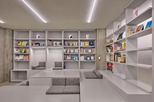 首尔Mangrove Sinseol的客厅设有书架和图书馆