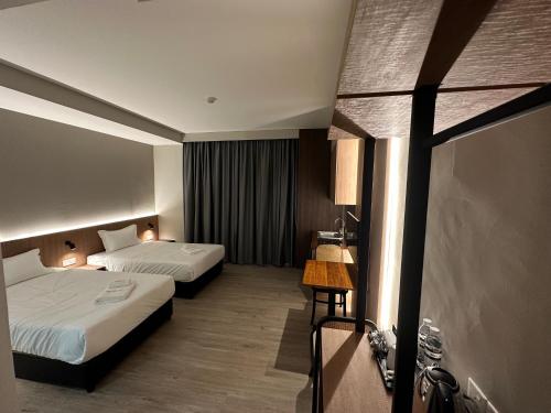 古晋Roxy Hotel Aiman的酒店客房设有两张床和窗户。