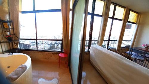 海法Amazing Panorama Bay view 3 room flat的一间带浴缸的浴室,位于带窗户的客房内