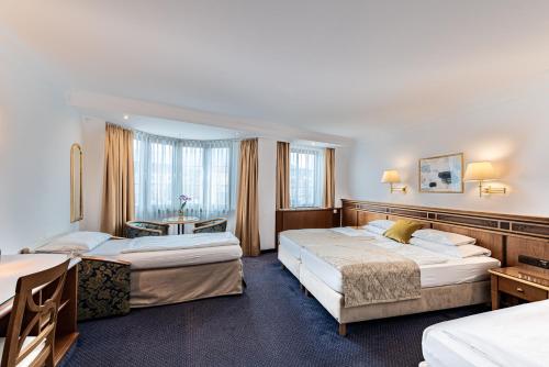 因斯布鲁克蒙德施恩酒店的酒店客房设有两张床和一张桌子。