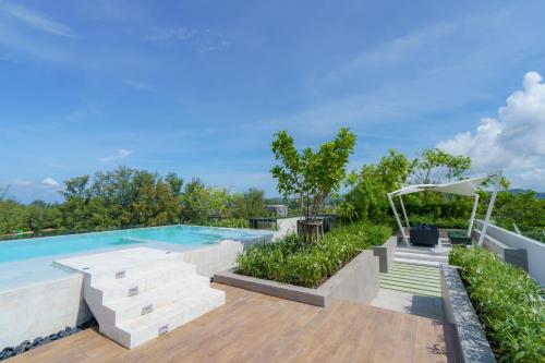 邦涛海滩Skypark Apartments by Laguna Phuket的一个带木制甲板和庭院的室外游泳池