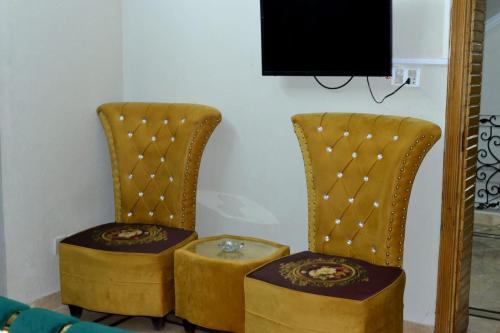 伊斯兰堡Galaxy Lodge的一张桌子和一台电视机的椅子