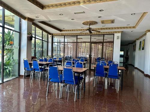 瓜埠Langkawi Baron Hotel - renovated 2023的一间设有蓝色椅子和桌子的用餐室以及窗户。