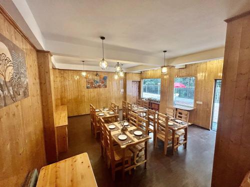 MirikAmaira Resort & Farms - Mirik, West Bengal的用餐室配有木桌和椅子